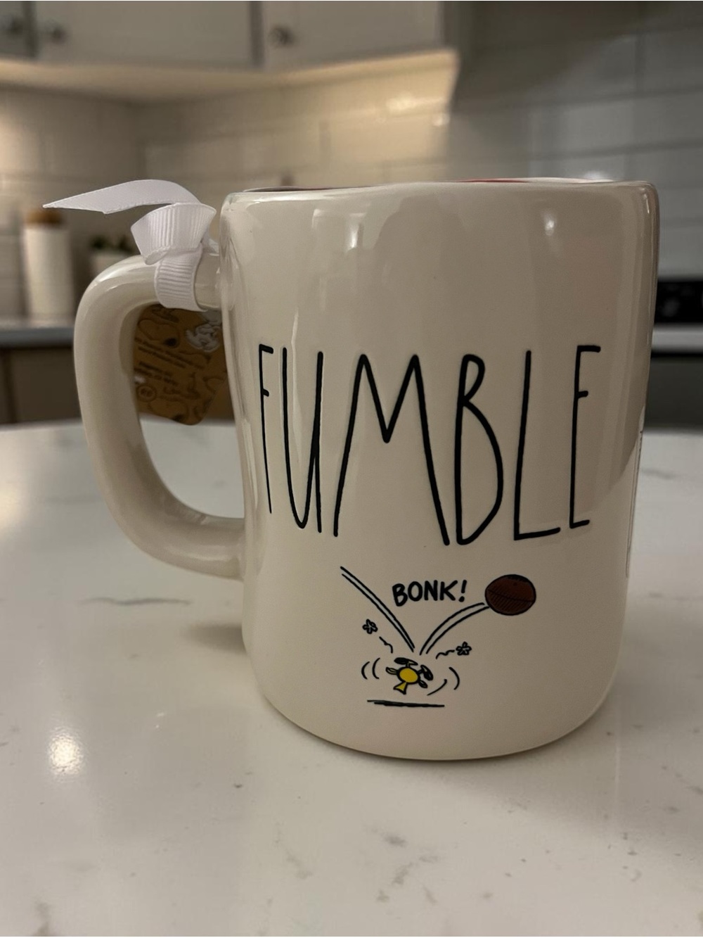Rae Dunn Ceramic Mug with football theme on it.